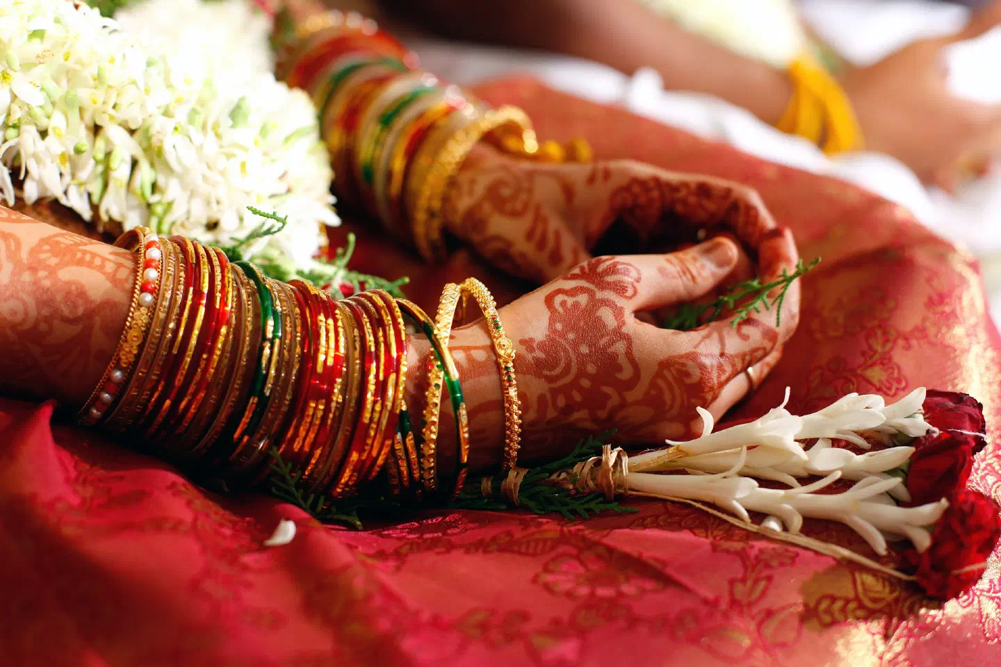 Wedding garlands and decorated hands during a ceremony
